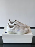 Pair of white low-top sneakers with blue logo embroidery on the sides