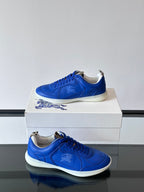 Blue lace-up sneakers with white soles, side view on a box