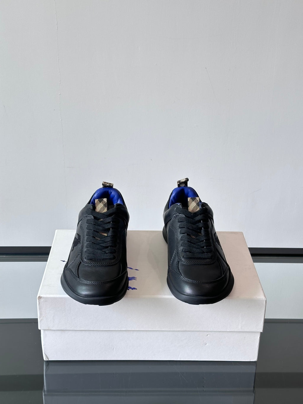 Burberry lace-up sneakers with blue interior lining, heel view on box