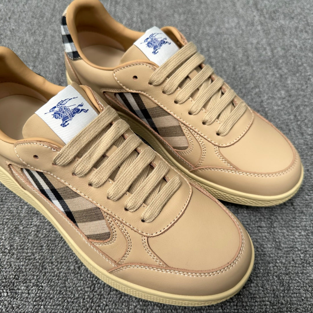 Close-up beige sneakers showing lace eyelets, plaid side panel, and embroidered polo logo