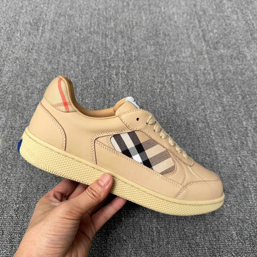 Beige low-top sneaker with lace-up front, plaid side panel, and textured outsole