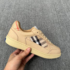 Beige low-top sneaker with lace-up front, plaid side panel, and textured outsole