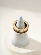 Gold-tone hoop ring with black enamel and light gray inner section