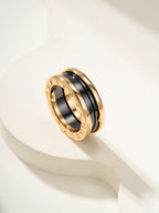 Gold-tone ring with black center inlay and engraved outer rim