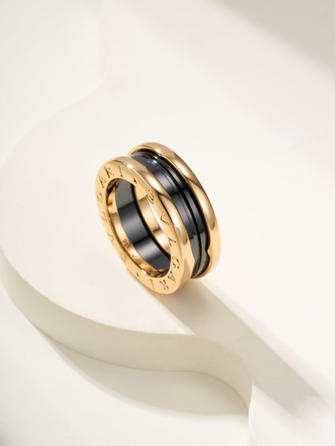 Gold-tone ring with black center inlay and engraved outer rim
