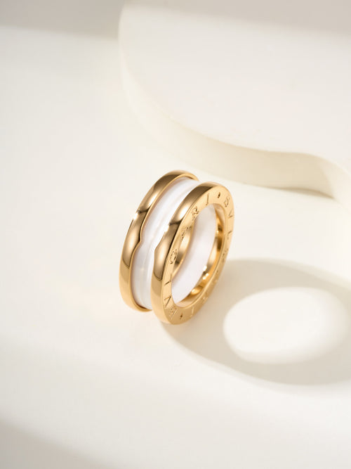 Gold-tone ring with white inlay and engraved inner surface