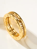 Gold ring with engraved initials and small clear stone accents on the band