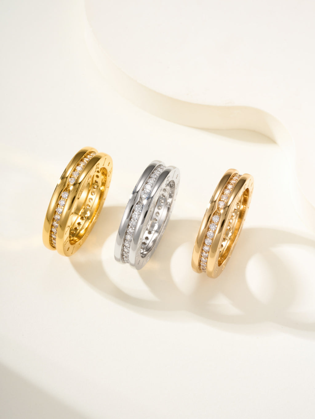 Set of three rings in gold and silver with sparkling stones along the bands