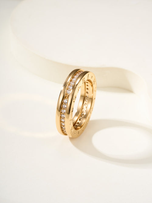 Gold ring with sparkling stones on two stacked bands, angled view