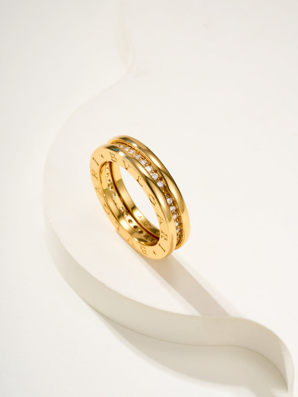 Gold ring with engraved band and small clear stones, angled close-up
