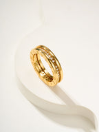 Gold ring with engraved band and small clear stones, angled close-up