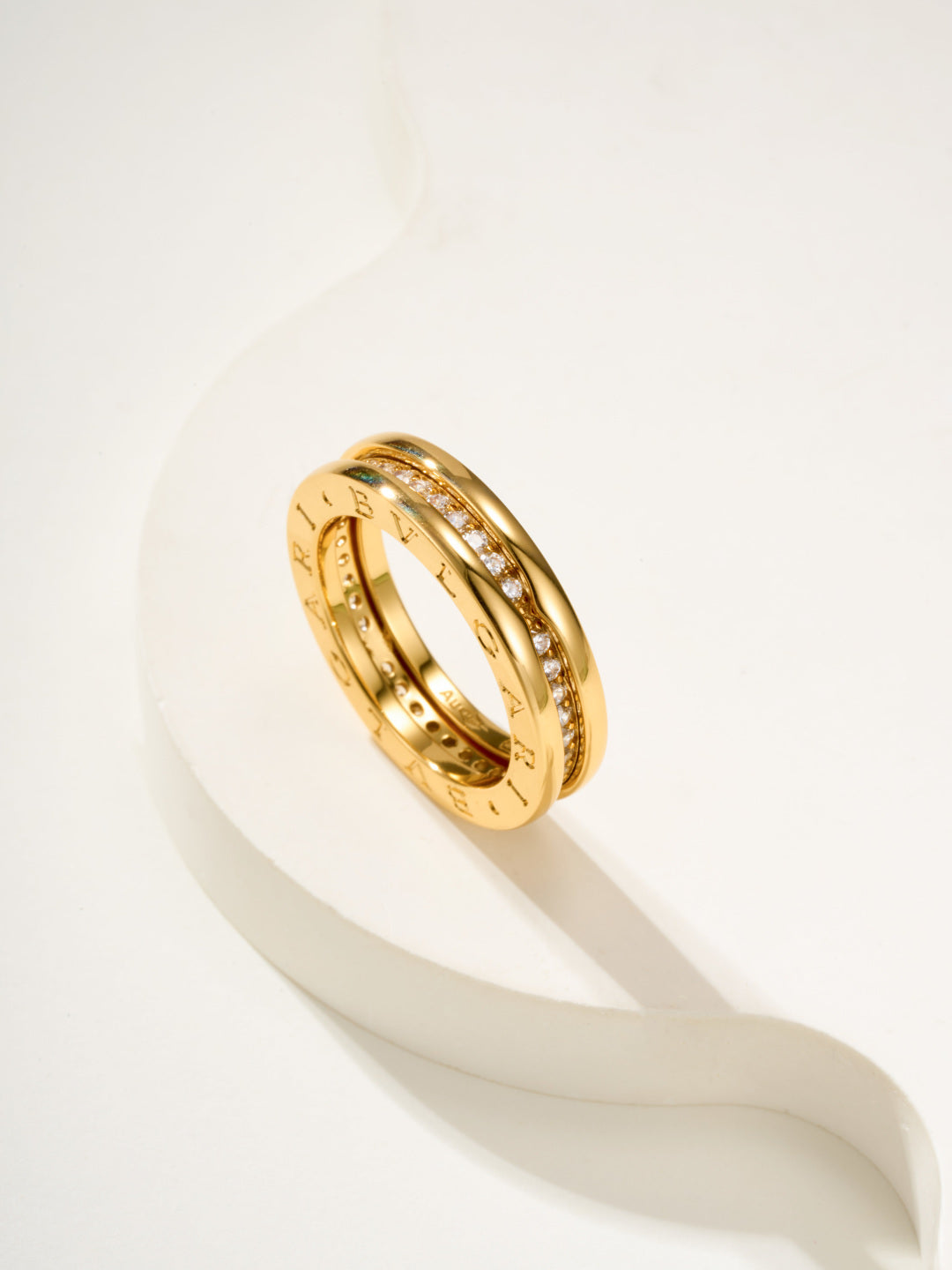 Gold ring with engraved band and small clear stones, angled close-up