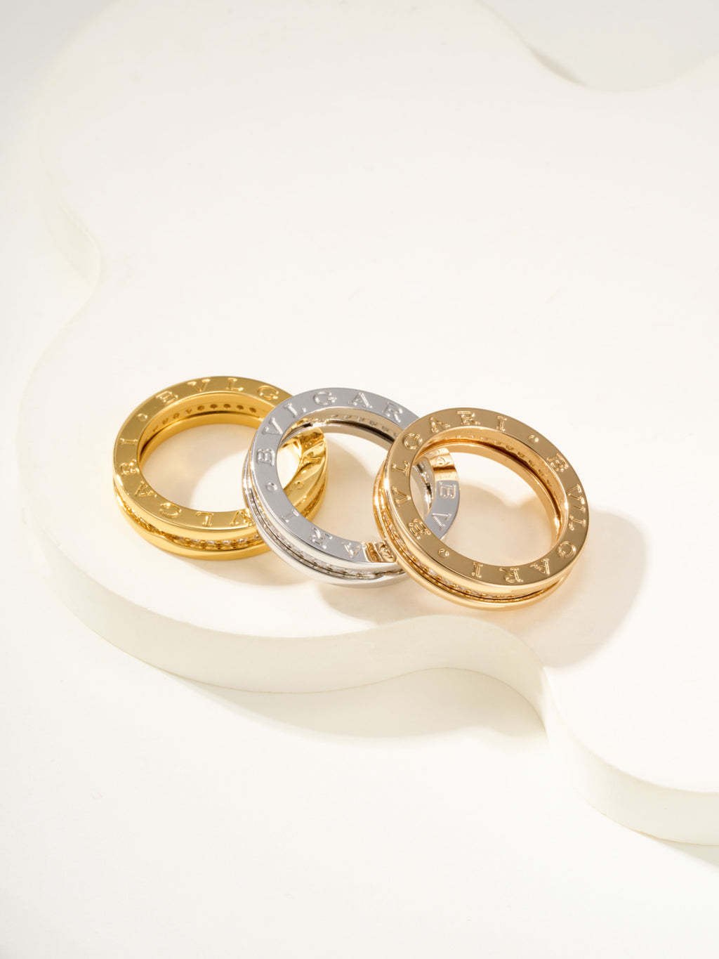 Assorted rings: gold, silver, and gold with sparkling stone bands, shown together