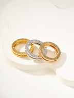 Assorted rings: gold, silver, and gold with sparkling stone bands, shown together