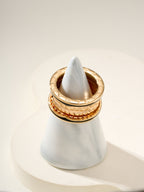 Bvlgari gold-tone ring on a white display cone, textured outer band
