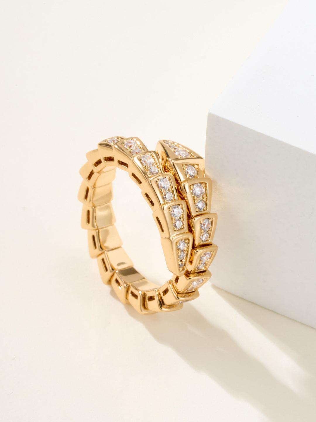 Bvlgari diamond ring, gold-tone linked band with square-cut stones, shown on pedestal