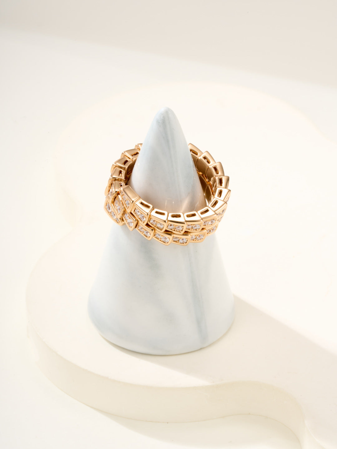 Bvlgari gold-tone pavé band ring on a ring stand, square crystal settings