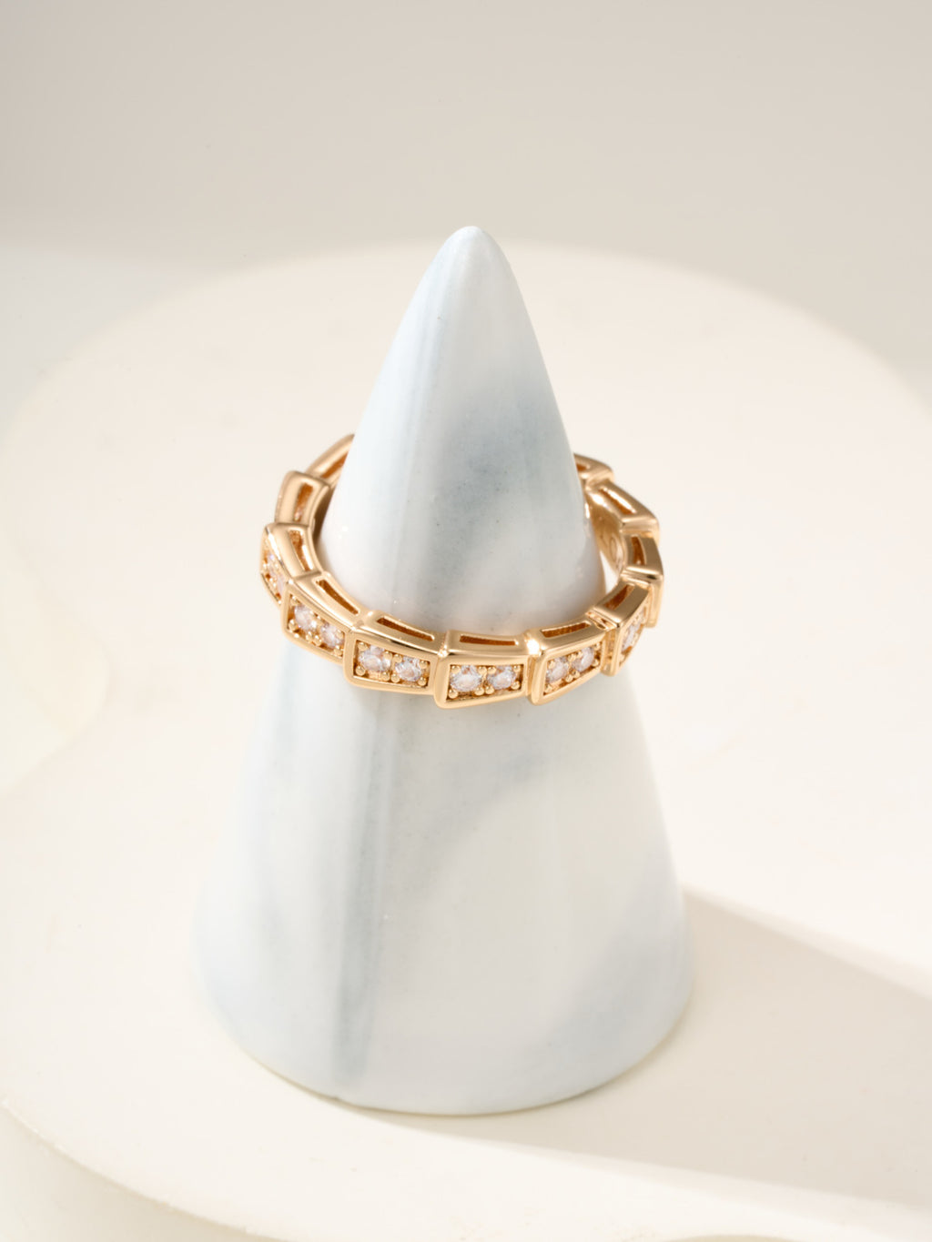 Gold gemstone bangle with rectangular settings and square-cut stones, slim profile.