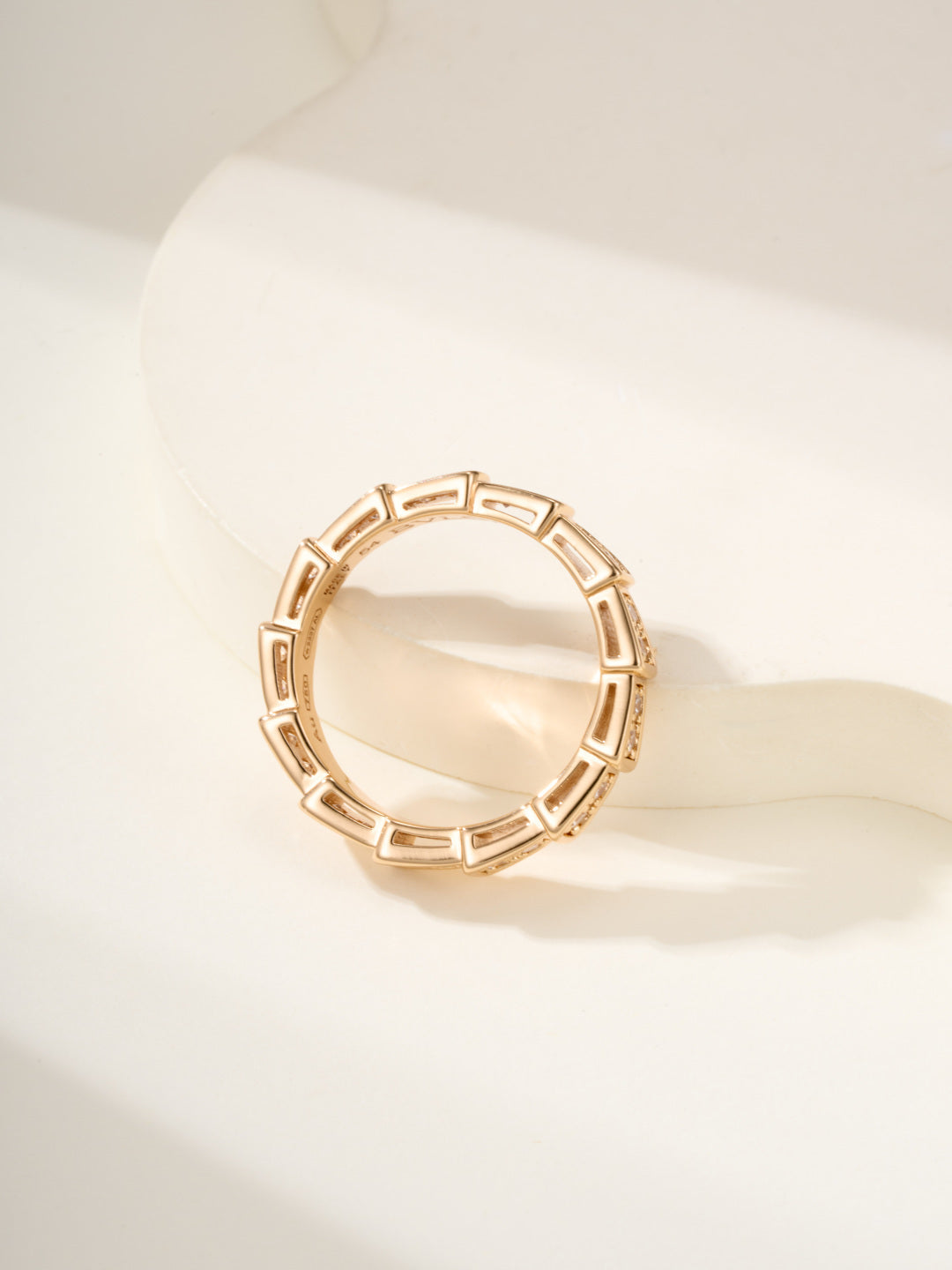 Gold gemstone bangle with bezel-set stones in a circular pattern.
