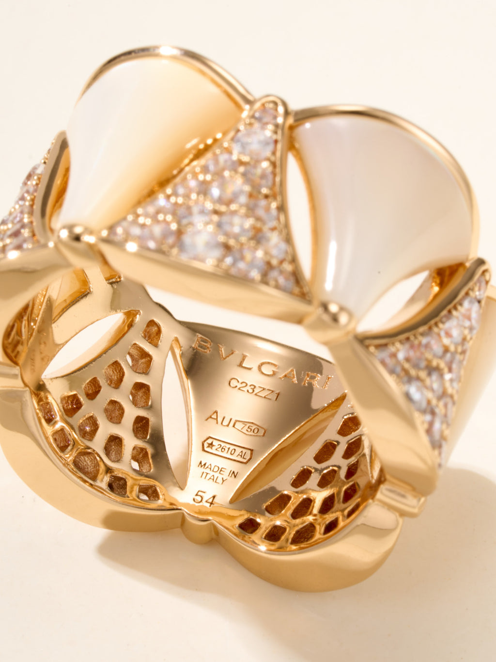Bvlgari gold-tone ring close-up with engraved interior and openwork patterned band.