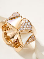 Bvlgari gold-tone ring with white teardrop insets and pavé crystal band, openwork edges.