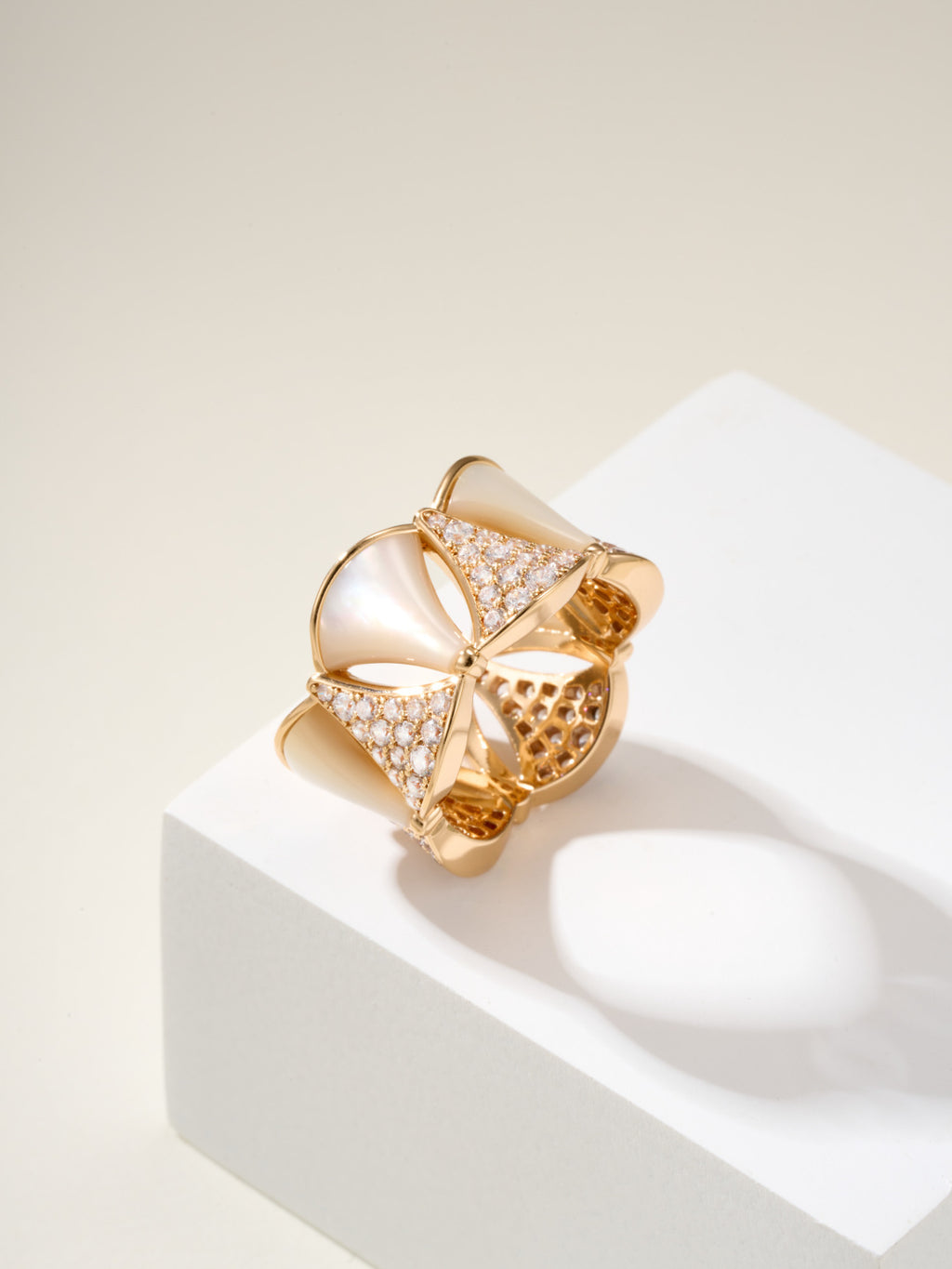 Bvlgari gold-tone ring with white teardrop insets and pavé crystal bands, openwork styling.