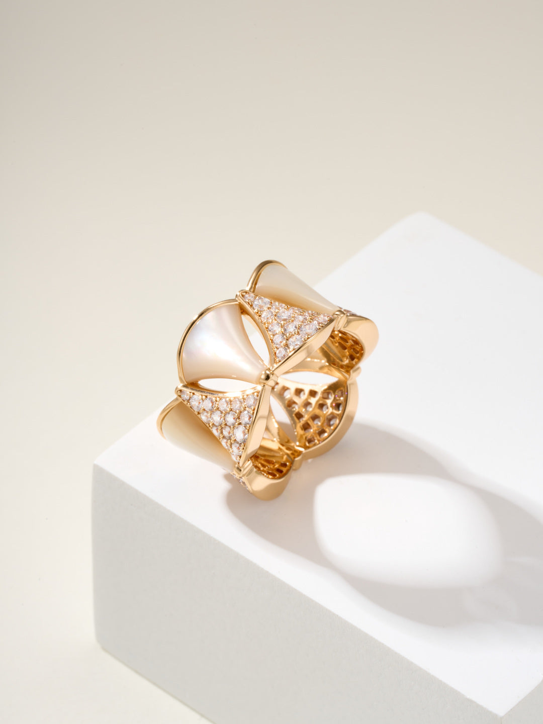 Bvlgari gold-tone ring with white teardrop insets and pavé crystal bands, openwork styling.