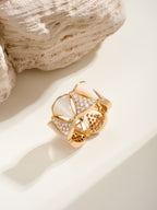 Bvlgari gold-tone ring with white teardrop insets, pavé stones, and openwork panels.