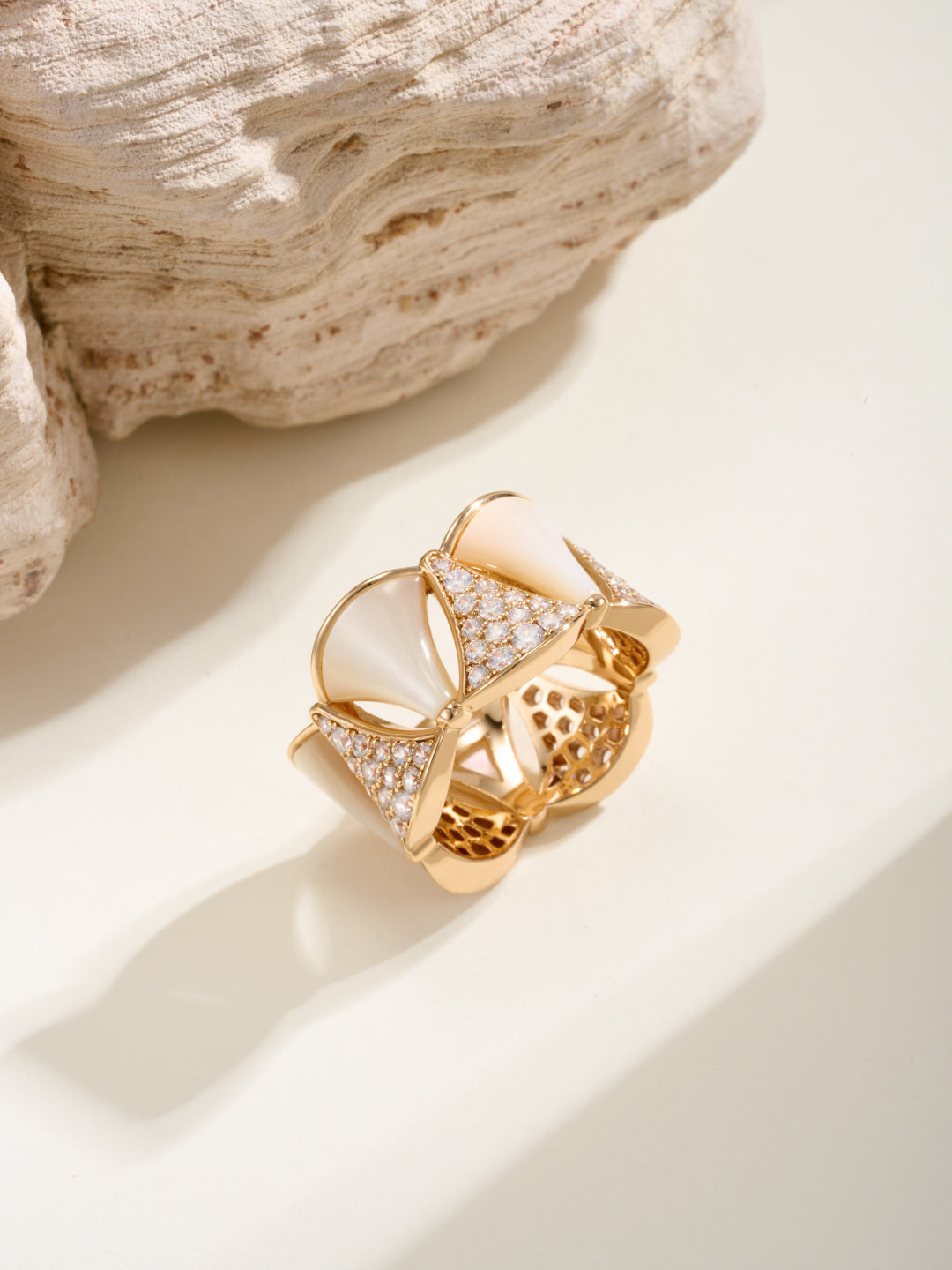 Bvlgari gold-tone ring with white teardrop insets, pavé stones, and openwork panels.