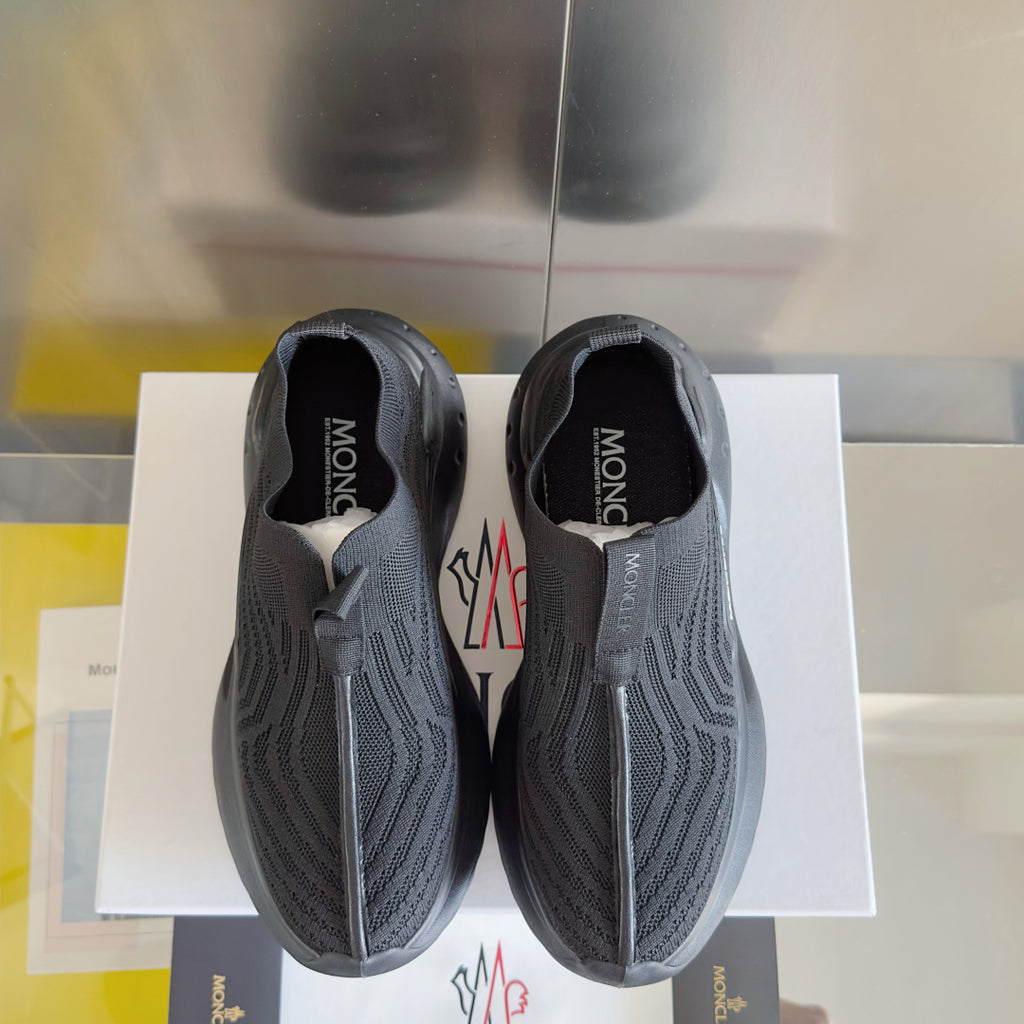 Moncler knit sneakers, top view of two slip-ons with logos on uppers