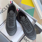 Moncler lace-up sneakers in dark gray with textured mesh panels and cushioned sole.