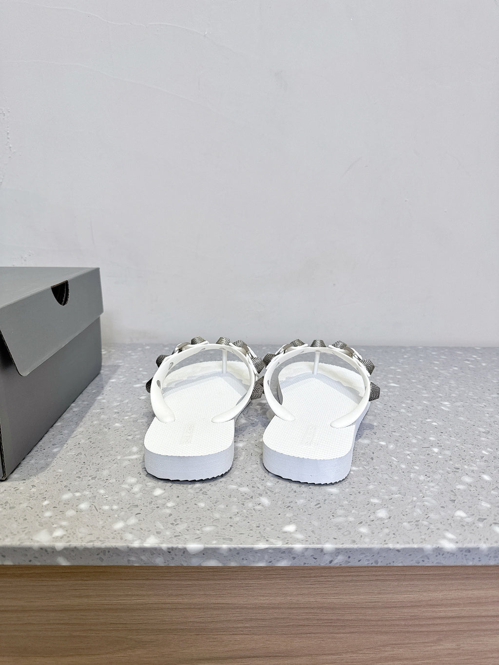 White thong sandals, heel-side view, studded strap detail with silver-toned hardware.