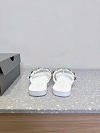 White thong sandals, heel-side view, studded strap detail with silver-toned hardware.