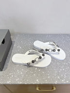 Pair of white thong sandals with studded strap accents and silver-toned hardware.