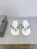 White thong sandals with studded oval hardware straps and cushioned footbeds.