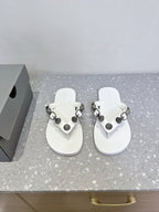 White thong sandals with studded oval hardware straps and cushioned footbeds.