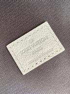 Louis Vuitton authenticity tag with debossed logo on light leather