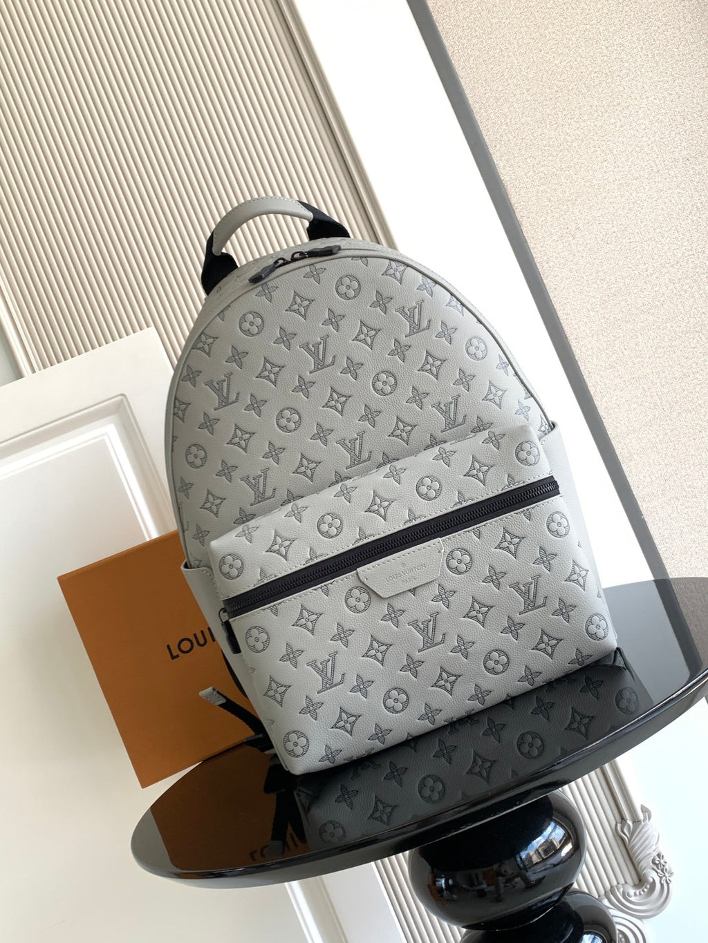 Louis Vuitton monogram bag with gray fabric, zip-top closure, and curved handles