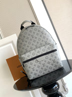 Louis Vuitton monogram bag with gray fabric, zip-top closure, and curved handles