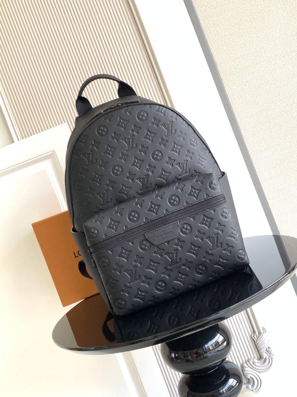 Louis Vuitton monogram backpack in dark embossed leather, front view with top handle