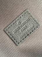 Louis Vuitton backpack leather tag with stamped logo text, close-up on fabric lining