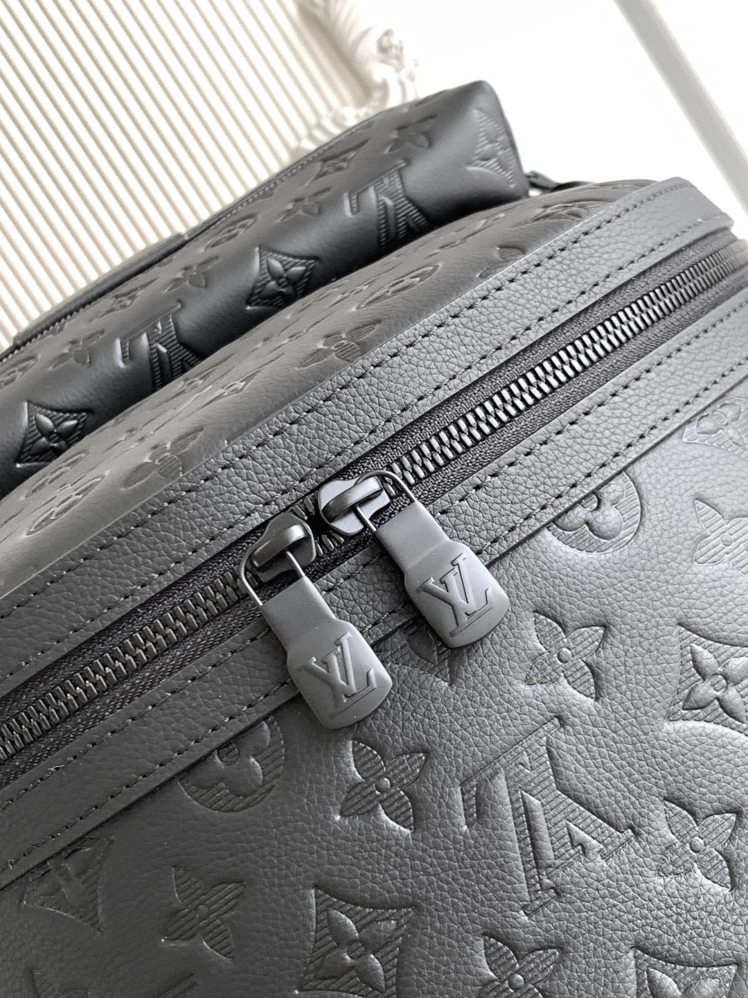 Louis Vuitton monogram backpack close-up of zipper, textured leather, and embossed pattern