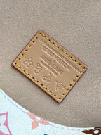 Brown leather label patch with Louis Vuitton embossing and yellow/gold stitching.