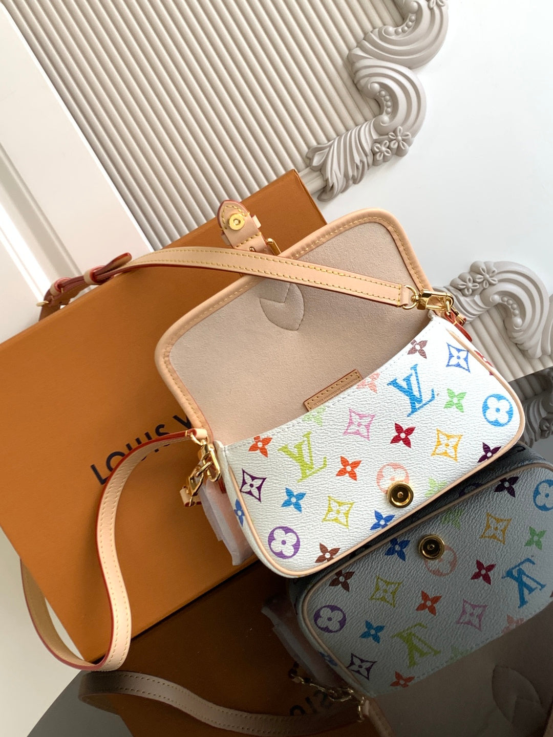 Multicolor monogram crossbody bag open with beige interior and gold clasp.