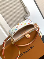 Multicolor monogram crossbody bag with open top and tan interior lining.