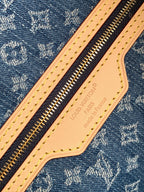 Blue monogram tote bag close-up: tan leather zip pull with Louis Vuitton imprint