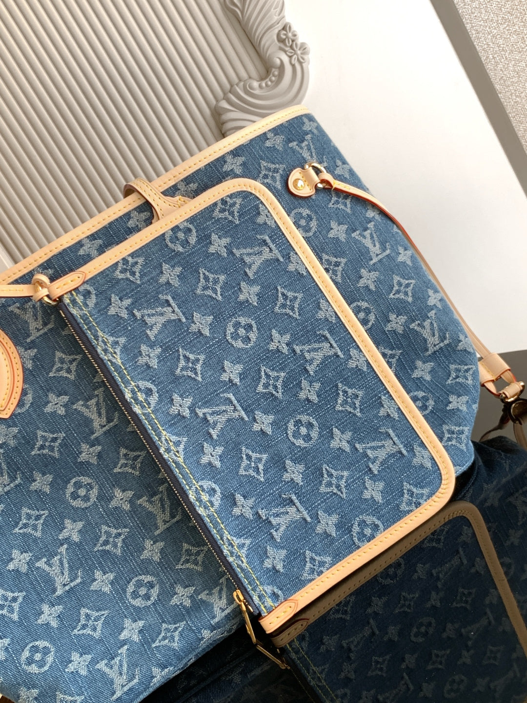 Blue monogram tote bag with tan crossbody strap and zippered front pocket