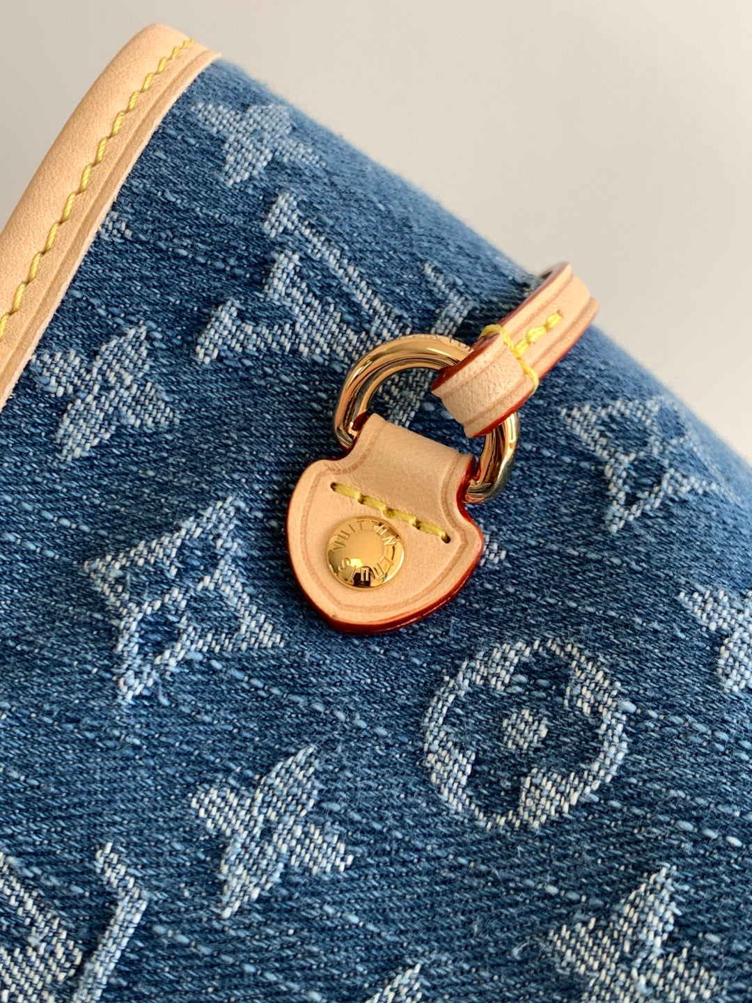 Blue monogram tote bag close-up: tan lock and gold-tone keyhole charm