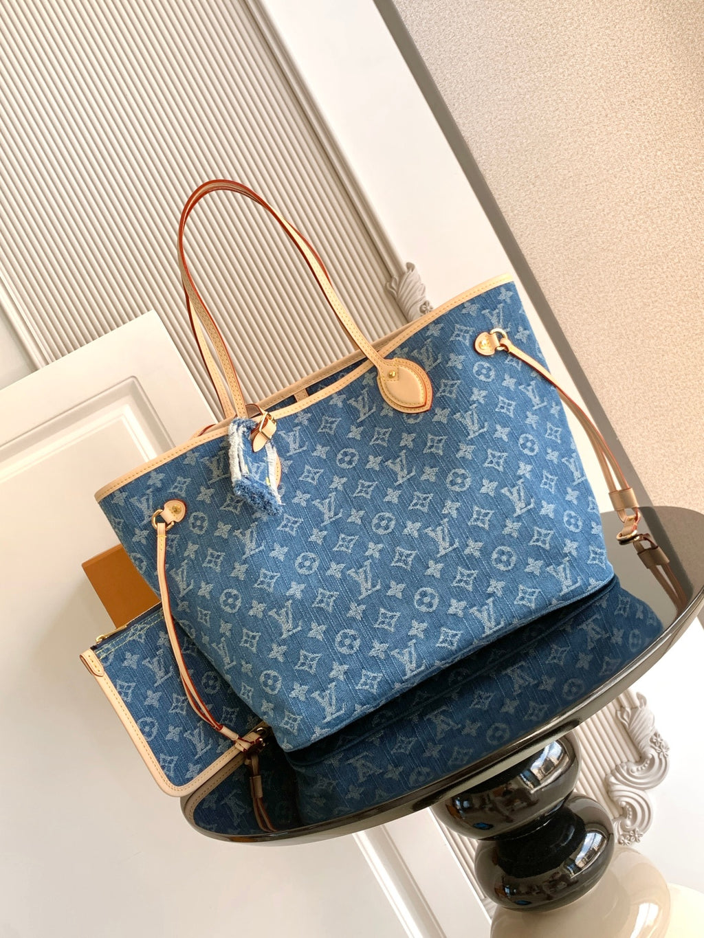 Blue monogram tote bag with tan leather handles and gold-tone hardware