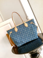Blue monogram tote bag with tan top handles, side straps, and gold hardware